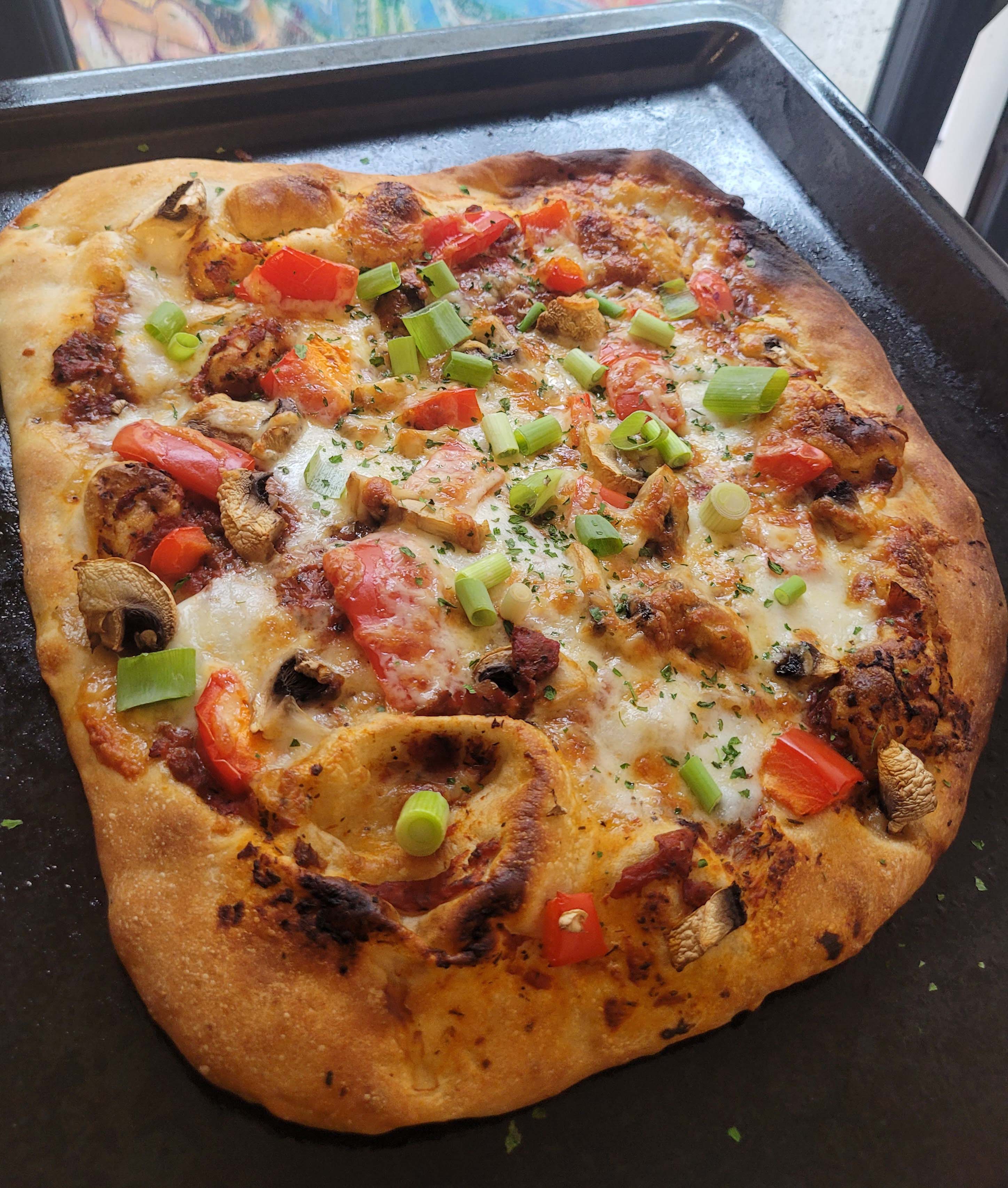 Pizza on a baking sheet.